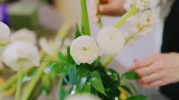 Hands female florist make up the composition of flowers — Stock Video