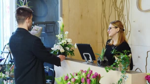 Бизнесмен покупает букет в цветочном магазине — стоковое видео