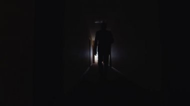 Bir insan karanlık koridorda yürüyor