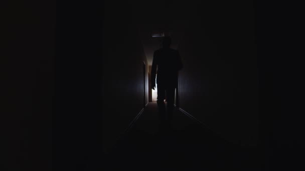 Un homme marche dans le couloir sombre — Video