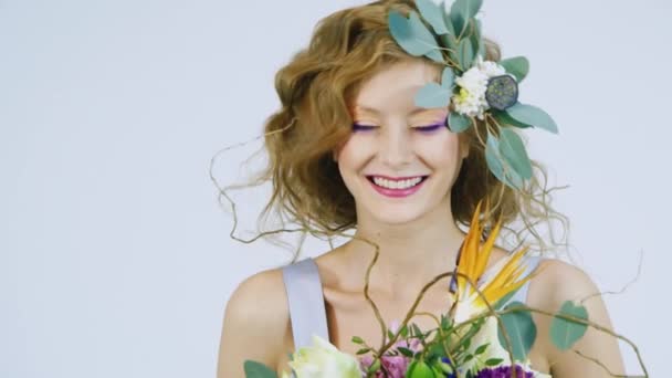 Retrato de uma jovem mulher segurando flores em seu cabelo — Vídeo de Stock