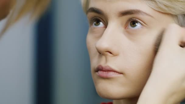 Maquillaje artista haciendo maquillaje mujer joven — Vídeos de Stock