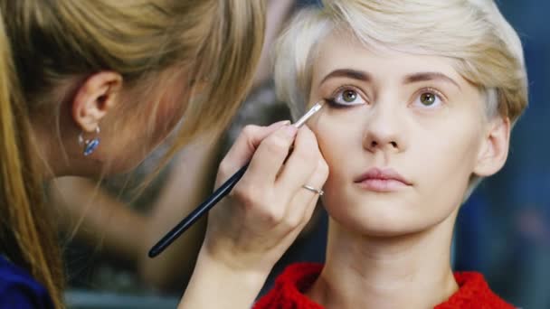 Visagistin macht Make-up junge Frau — Stockvideo