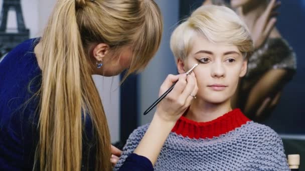 Linda chica haciendo maquillaje en el salón — Vídeo de stock
