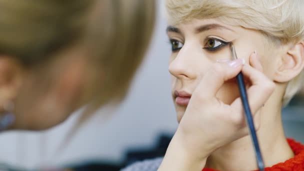 Een aantrekkelijke vrouw met een kort kapsel toegepast make-up — Stockvideo