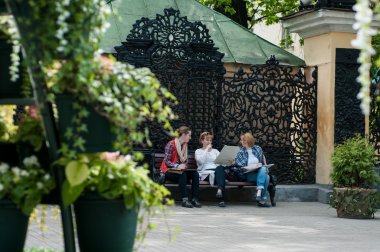 bankta oturan üç kadın arkadaş