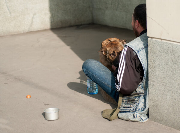 homeless people and dog  on city street