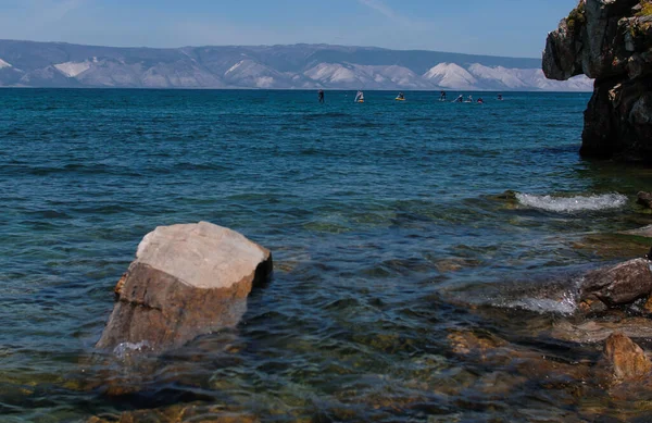 Pessoas na seiva surfar na água azul do Lago Baikal — Fotografia de Stock