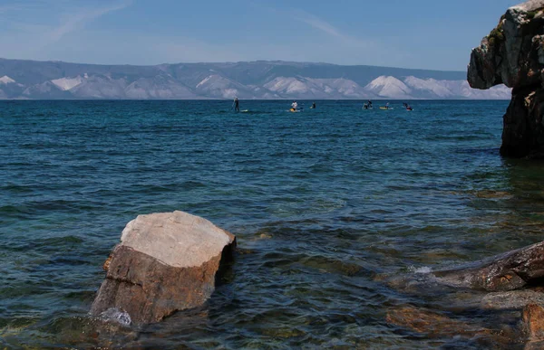 Pessoas na seiva surfar na água azul do Lago Baikal — Fotografia de Stock