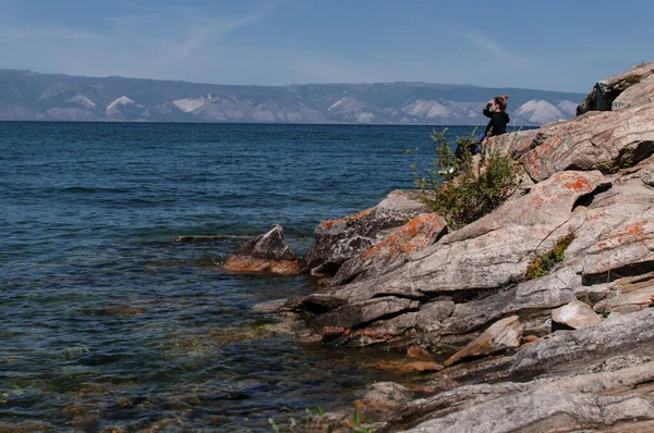 Woman on a rocky shore near the water of Lake Baikal — Stock Photo, Image