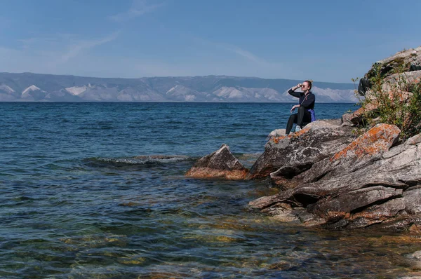 Mulher em uma costa rochosa perto da água do Lago Baikal — Fotografia de Stock