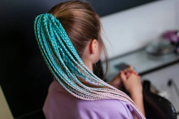 손으로 고무줄을 사용하여 푸른색의 액세서리는 실내에 금발의 소녀에 나타난다 — 스톡 사진