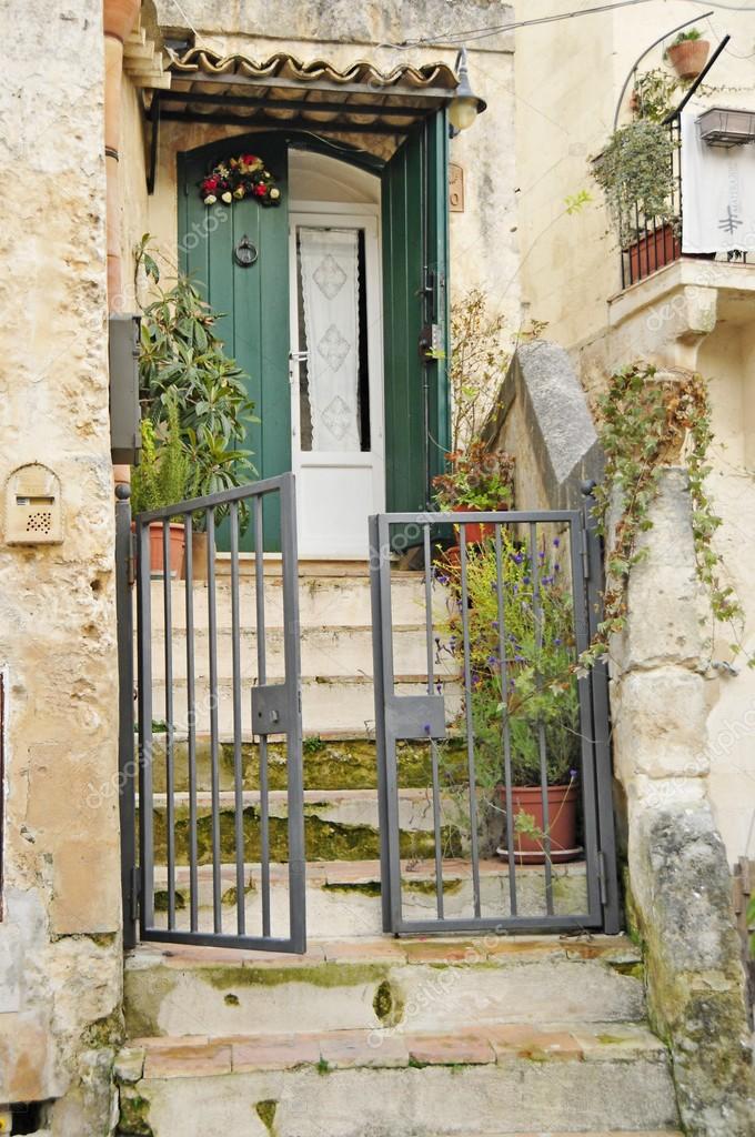 Puerta vieja con un patio lleno de flores — Foto de stock © oksy001