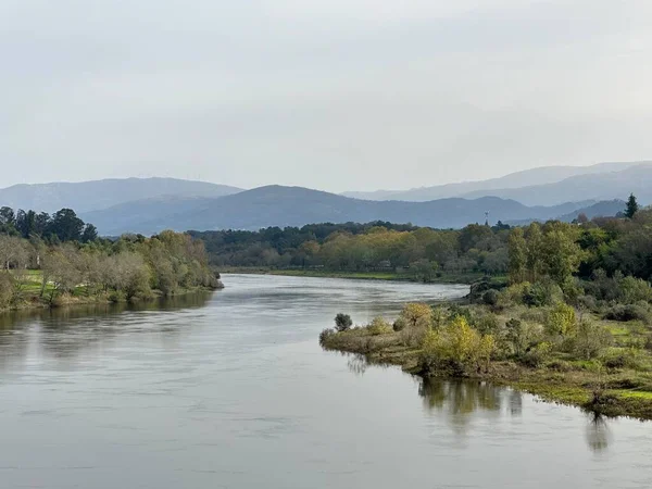 Arkasında bulutlu bir gün olan güzel bir nehir manzarası.