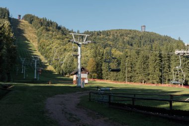 Boguszow-Gorce, Polonya - 21 / 09 / 2025: Dzikowiec kayak merkezinin bir teleferiği ve Dzikowiec Wielki Dağı 'nda yeni bir gözlem kulesi ile manzarası. Aşağı Silezya 'da popüler bir gözlem kulesi.