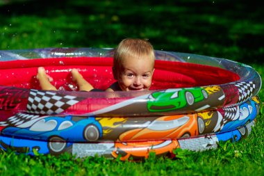 Şişme havuzda küçük çocuk plashes
