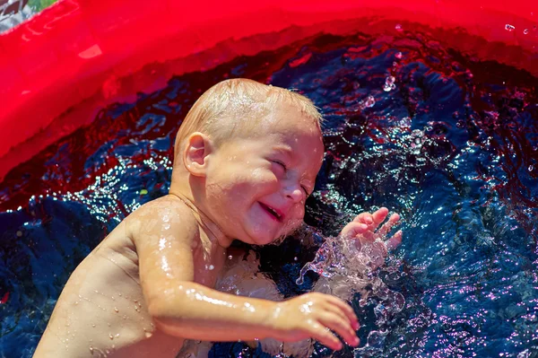 Liten pojke stänk i Uppblåsbara poolen — Stockfoto