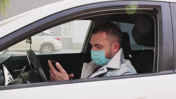 Un hombre de cerca con una máscara en la cara en el coche. — Vídeos de Stock
