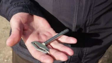 Yakın plan bir adam elinde büyük bir garaj anahtarı tutuyor.