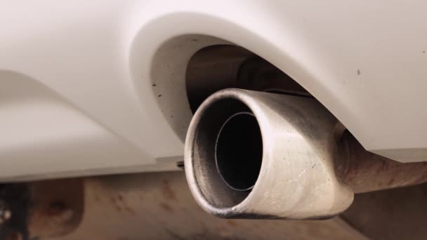 Gros plan du tuyau d'échappement d'une voiture blanche en état de marche. — Video