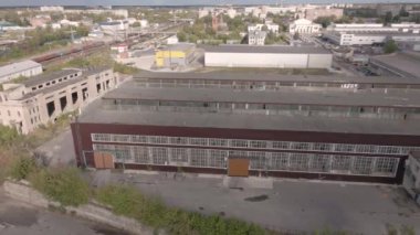 Atölyeleri ve yeşil ağaçları olan bir sanayi bölgesi üzerinde uçmak.