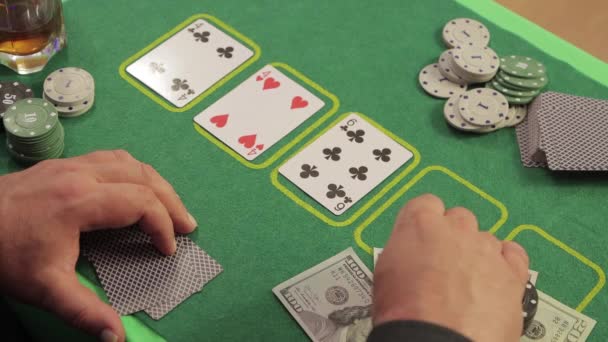 Ein Mann in einem Casino an einem Spieltisch macht eine Wette mit Chips — Stockvideo