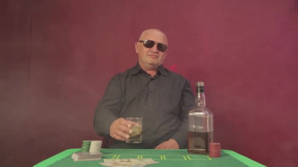 Muž v kasinu u hazardního stolu pozvedne sklenici whisky.. — Stock video