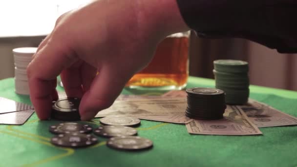La main dans le casino à la table de jeu recueille des jetons noirs. — Video