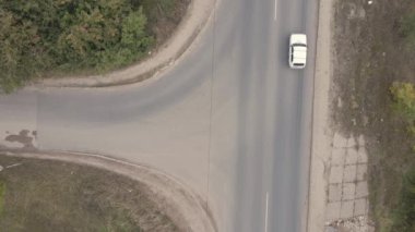 Hareket halindeki arabalarla küçük bir banliyö kavşağının üst görüntüsü.