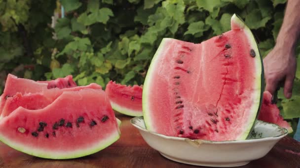 Detailní záběr muže, jak krájí půl melounu na plátky. — Stock video