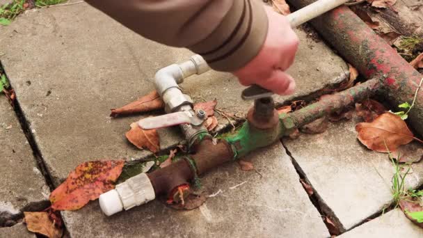 Uma mão de homem desliga uma torneira de metal no sistema de encanamento — Vídeo de Stock