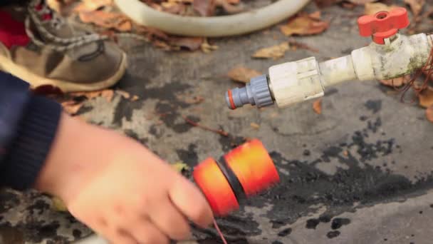 As mãos meninos conectar tubos de água de plástico. — Vídeo de Stock