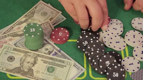 Gros plan d'une main dans un casino à une table de jeu recueille des jetons. — Video