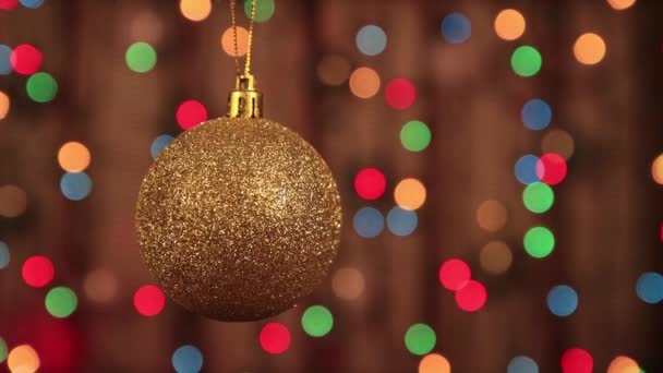 Vánoční ozdoba na stromě zlatý míč visí a houpe. — Stock video