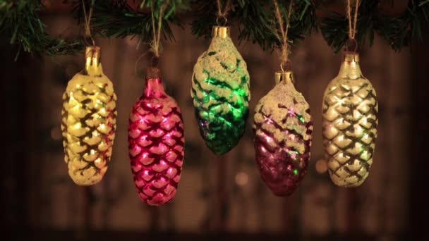Vánoční ozdoba - vinobraní borovicové kuželové hračky se zelenými laserovými paprsky. — Stock video