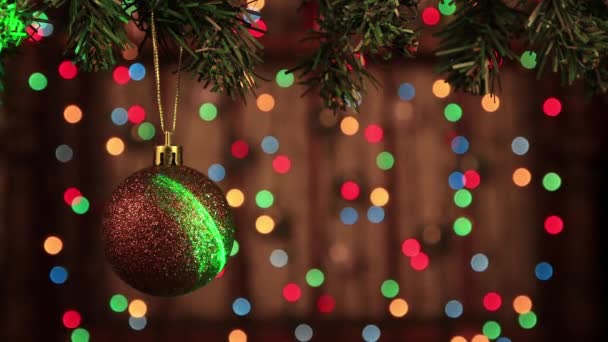 Weihnachtsschmuck am Baum mit einer braunen Kugel und einem beweglichen Laserstrahl. — Stockvideo