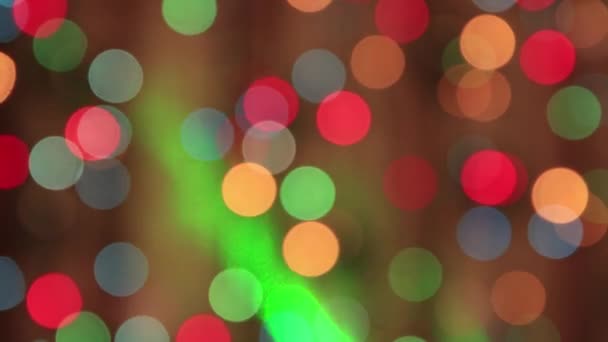 Luces festivas oscilantes multicolores en la oscuridad con un rayo verde rápido. — Vídeo de stock