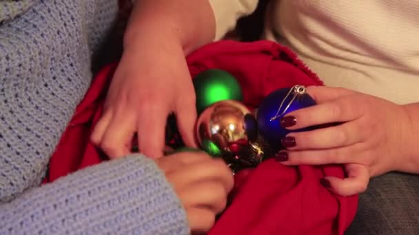 Noel toplarını kırmızı bir çantada parmaklayan elleri yakın plan.. — Stok video