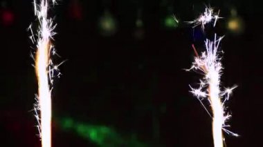 Yeni yıl havai fişekleri yanar ve yukarı doğru beyaz kıvılcımlar atar..