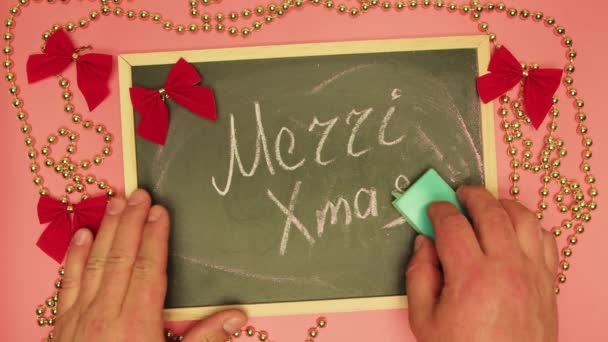 Een mensenhand wist Merry Xmas op een zwarte tablet en schrijft het einde. — Stockvideo