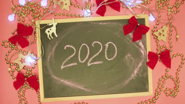 A man kézzel törli 2020 egy fekete táblán, és azt írja 2021. — Stock videók