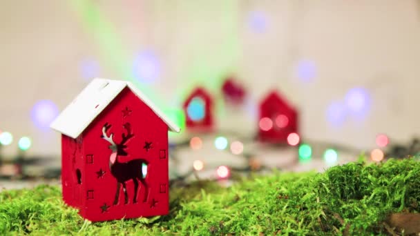 Casa vermelha com um veado, decoração de árvore de Natal com bokeh de volta. — Vídeo de Stock