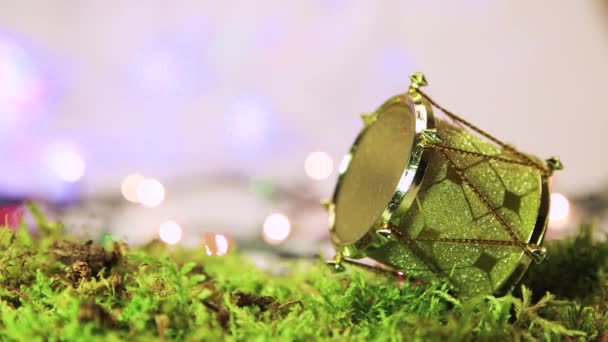 Tambor de oro sobre musgo verde, decoración del árbol de Navidad con espalda bokeh. — Vídeos de Stock