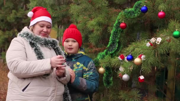 Mam en zoon zijn vrolijk schieten een klapbord op straat. — Stockvideo