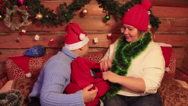 Mamá se está divirtiendo con su hijo en el sombrero rojo de Santa Claus. — Vídeos de Stock