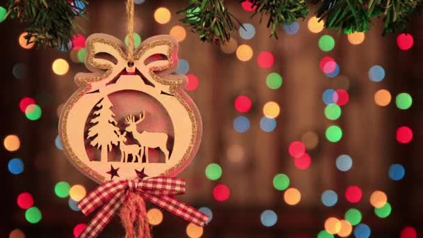 Χριστουγεννιάτικη διακόσμηση, ξύλινη μπάλα και μικρό ελάφι δίπλα στο δέντρο. — Αρχείο Βίντεο