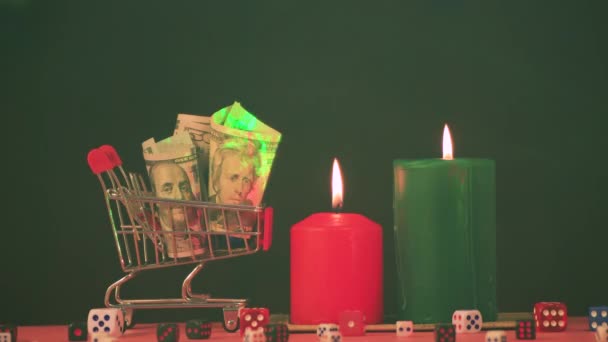 Een mand met geld en kerstkaarsen met een groene straal in de rook. — Stockvideo