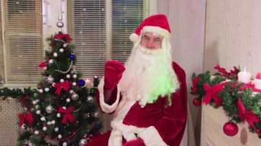 Noel Baba bir klape vurur ve başını ve kollarını sallar..