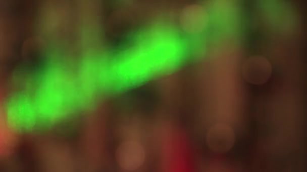 Slavnostní jemná bílá světla ve tmě a rychle se pohybující zelené a červené paprsky. — Stock video