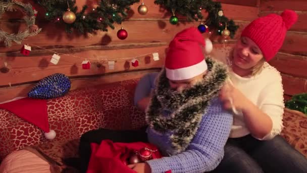 Mutter spielt und küsst ihren Sohn im roten Hut des Weihnachtsmannes. — Stockvideo